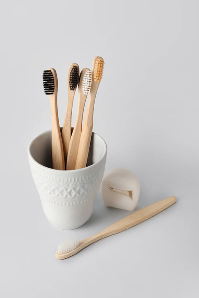 Holder with tooth brushes and floss on white background - Fotografie, Obrázek