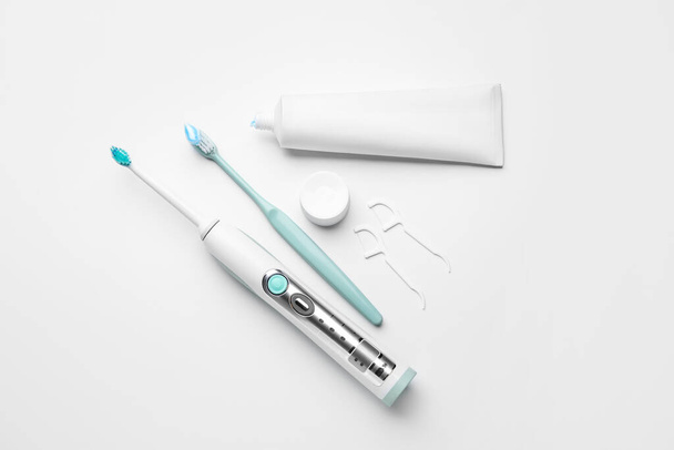 Escovas de dentes diferentes e colar no fundo branco - Foto, Imagem