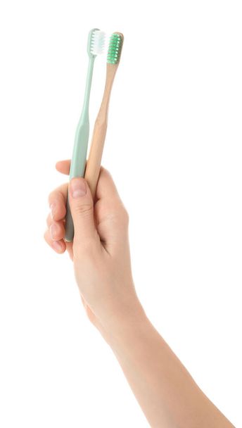 Γυναικείο χέρι με οδοντόβουρτσες σε λευκό φόντο - Φωτογραφία, εικόνα
