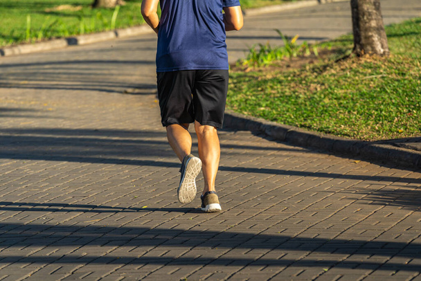 Young man jogging at the park in sunny morning - Photo, image