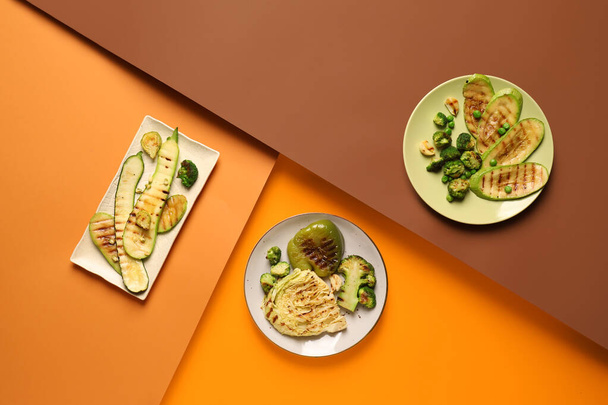 Assiettes avec de savoureux légumes grillés sur fond de couleur - Photo, image