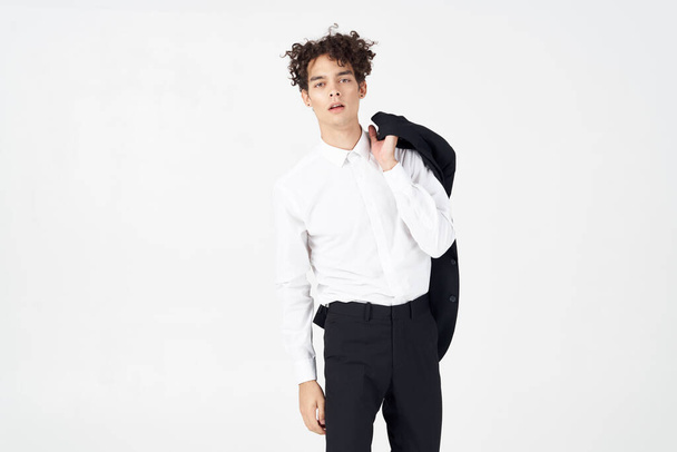 curly guy in a jacket shirt and trousers on a light background cropped view of the model - Φωτογραφία, εικόνα