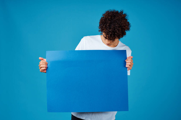 хлопець у білій футболці синій плакат рекламний банер
 - Фото, зображення