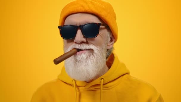 Starší starší muž relaxační uvnitř Spokojený starý muž kouření v moderním studiu.  - Záběry, video