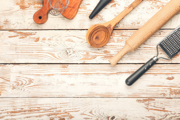 Zestaw naczyń kuchennych na jasnym drewnianym tle - Zdjęcie, obraz