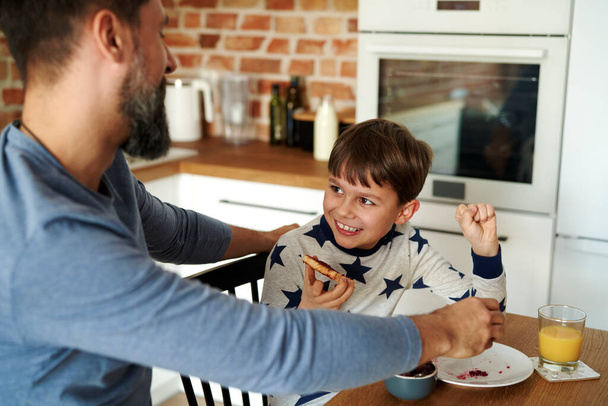 Hombre adulto medio desayunando con su hijo - Foto, Imagen