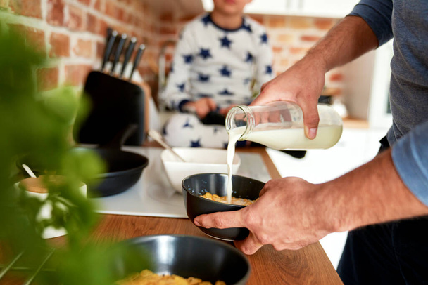 Крупним планом чоловік готує сніданок для свого сина
                                - Фото, зображення