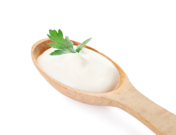 Cuchara con sabrosa crema agria sobre fondo blanco - Foto, Imagen