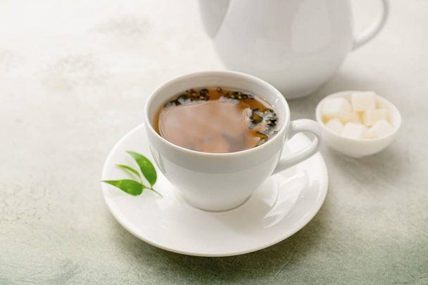 Cup and teapot of green tea on light background - Valokuva, kuva