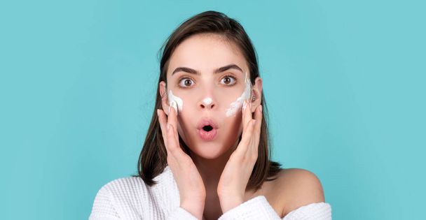 Beauty amazed woman with clean healthy skin, natural make up, spa concept. Beautiful excited girl apply a cleansing mask on face. - Foto, immagini
