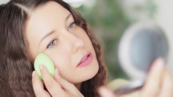 Beautiful woman applying natural organic makeup using beauty blender and smiling, eco make-up sponge tool, face portrait of caucasian model or vlogger as cosmetic product, skincare and people concept - Footage, Video