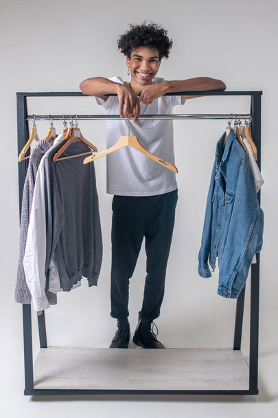 African american young guy standing near hangers with clothes - Fotografie, Obrázek