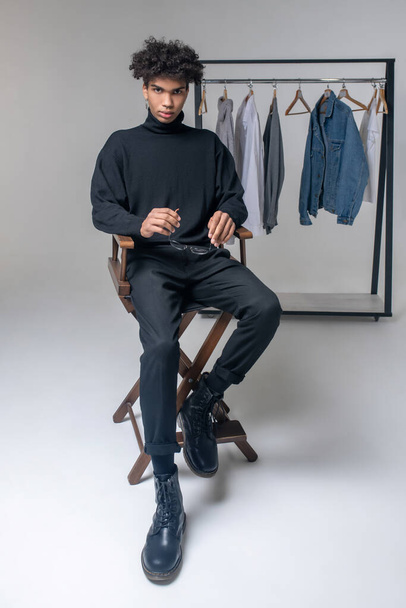 Africano americano joven chico usando negro ropa buscando grave - Foto, Imagen