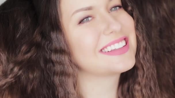 Beautiful woman with long healthy shiny curly hair, brunette model with wavy heatless curls hairstyle, perfect white teeth smile, beauty face portrait and natural organic haircare commercial - Footage, Video