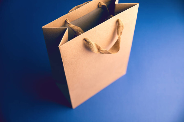 bolsa de regalo marrón sobre mesa azul - Foto, Imagen