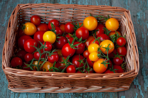 Red and yellow cherry tomatoes basket top view. Harvest vegetables. Tomato on the table. Vitamin healthy food. - Valokuva, kuva