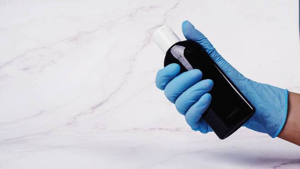 hands in medical gloves hold antiseptic to prevent a pandemic. desinfection hand sanitizer applying alcohol. - Photo, Image