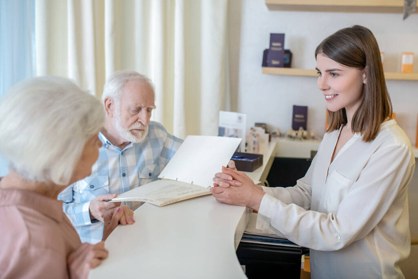 Elderly couple choosing procedures with a specialist in a spa center - Foto, Imagen