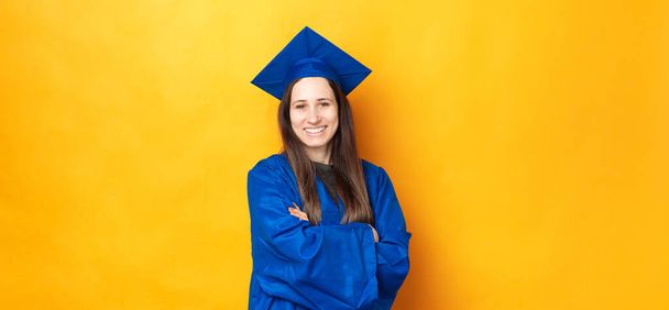 Retrato de sorrir jovem alegre mulher graduando e vestindo roupão azul. - Foto, Imagem