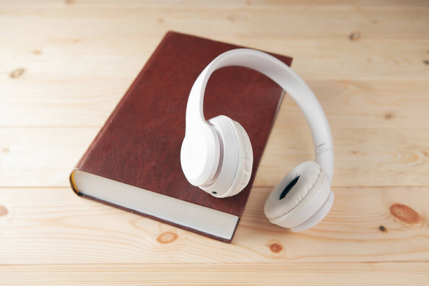 white white headphones on the book and a magnifier - Фото, зображення