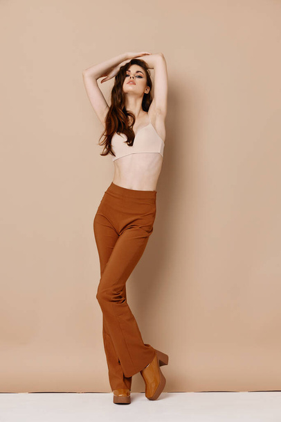 stylish woman in virtualquery pants holds her hand above her head - Foto, Imagem