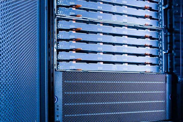 server rack with uncovered data storage arrays filled with hard drives - internet cloud provider concept - Photo, Image