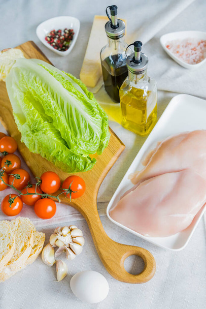 Sada produktů pro přípravu klasického Caesarova salátu. Salát, kuřecí prsa, třešně, krutony, česnek, vejce, olivový olej, Worcestershire omáčka, sůl, pepř. - Fotografie, Obrázek
