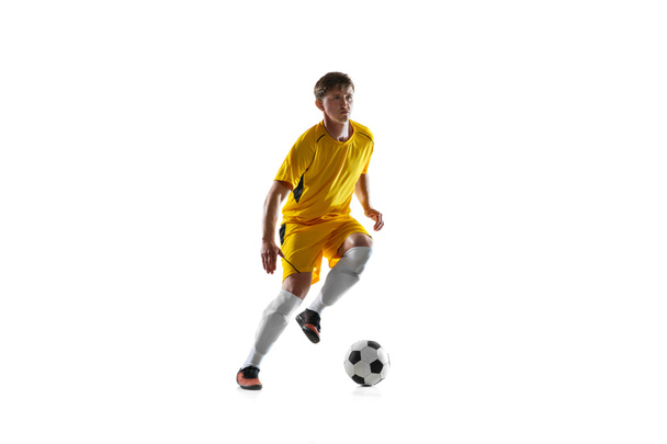 若い男,白い背景に隔離された男性サッカー選手のトレーニング. - 写真・画像