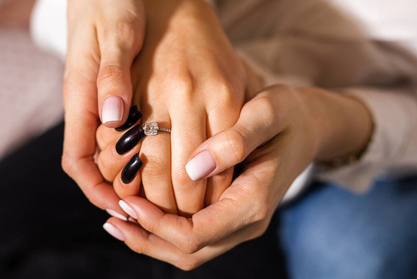 Vystřižená fotka dvou rukou nerozpoznatelných žen, svatební den. Pojem sňatek návrh v homosexuálním páru, láska je láska, zásnubní prsten - Fotografie, Obrázek