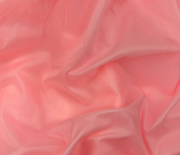 Roze zijden textuur bovenaanzicht. Rood koraal glanzend satijnen achtergrond. Mode kleur vrouwelijke kleding trend. Vrouwelijke blog achtergrond tekst teken ontwerp.Girly abstract behang glad textiel oppervlak. - Foto, afbeelding