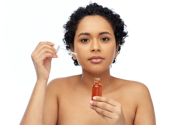 african american woman with bottle of serum - Foto, afbeelding