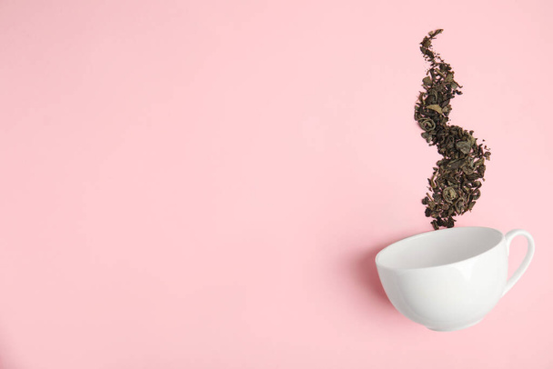 Dry tea brew and cup on pink background, flat lay. Space for text - Φωτογραφία, εικόνα