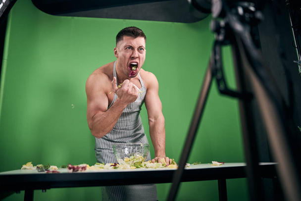 Muskelkräftiger Mann nimmt Video für Bodybuilding-Blog auf und schreit - Foto, Bild