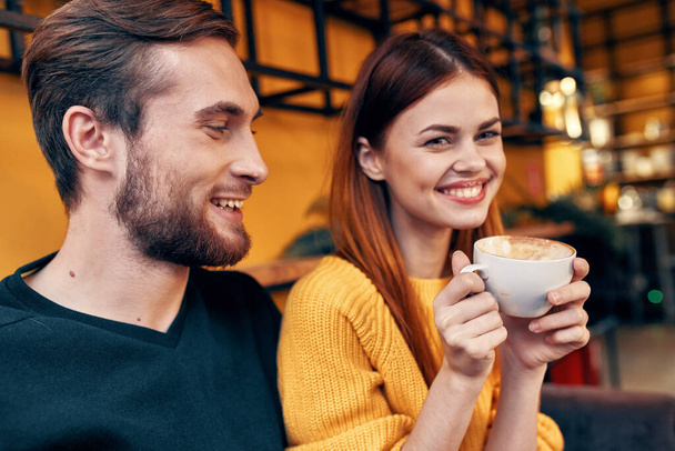 portrait of a man in a sweater and a woman with a cup of coffee interior room - Foto, imagen