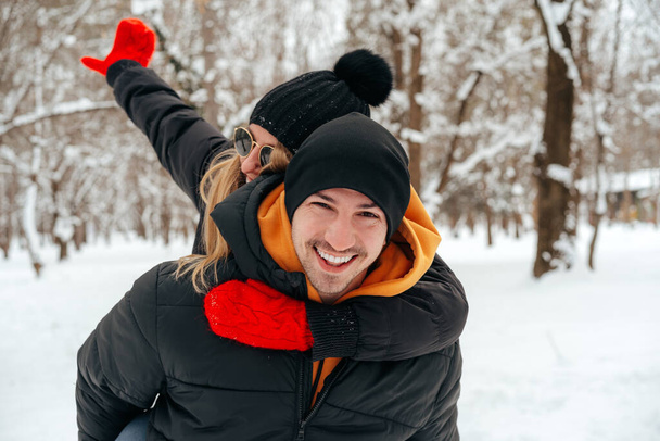 Happy couple hugging and smiling outdoors in snowy park - Photo, image