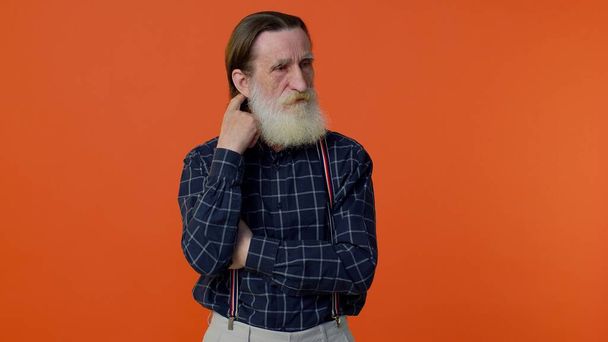 Вдумчивый умный старый бородатый мужчина трёт подбородок, размышляя над решением, сомневаясь в вопросе - Фото, изображение