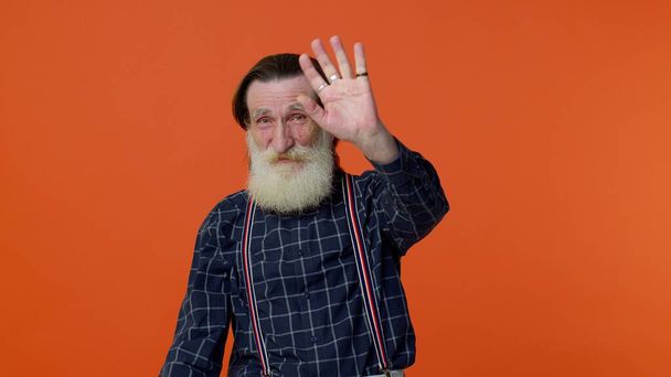 Счастливый дружелюбный пожилой человек машет рукой ладонью в привет жест приветствует кого-то положительные эмоции - Фото, изображение