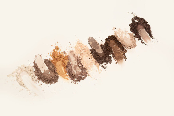Cracked kit of eye shadow in basic brown colors on a grey background - Zdjęcie, obraz