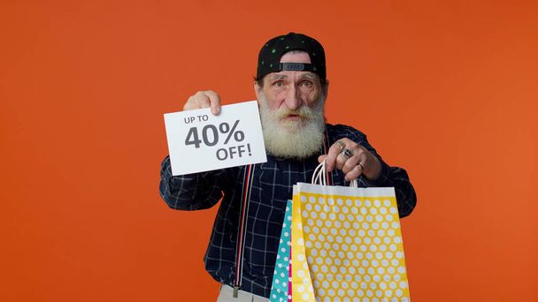 Starszy brodaty mężczyzna pokazuje torby na zakupy i do 40 Procent off napisy tekst, Czarny Piątek - Zdjęcie, obraz