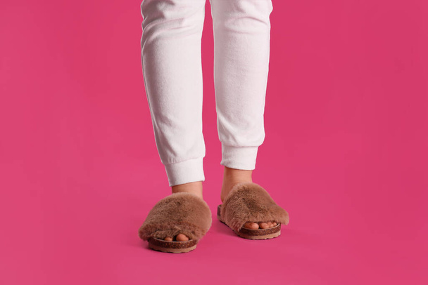 Woman in fluffy slippers on pink background, closeup - Zdjęcie, obraz