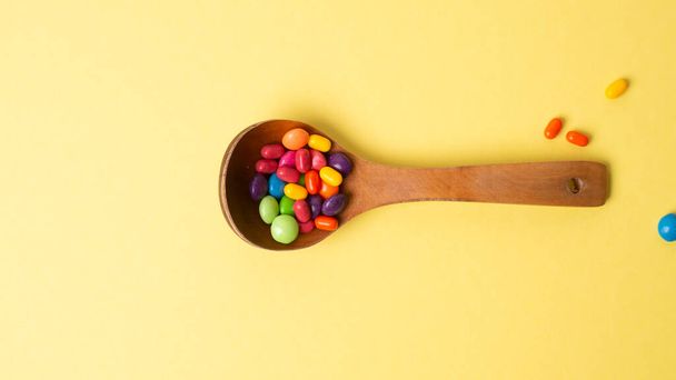 ensemble de bonbons multicolores avec une cuillère en bois - Photo, image