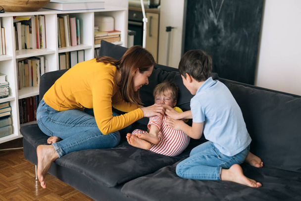 mother cuddling with her kids at home - Zdjęcie, obraz