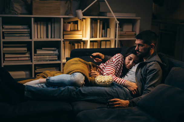 молодая пара смотрит телевизор дома. вечерняя сцена - Фото, изображение
