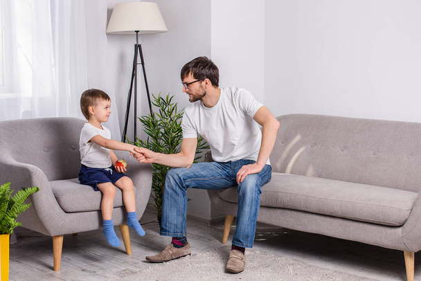 Father and young son discussing something serious in the living room at home. Family of trust. Relationship psychology. - Фото, зображення