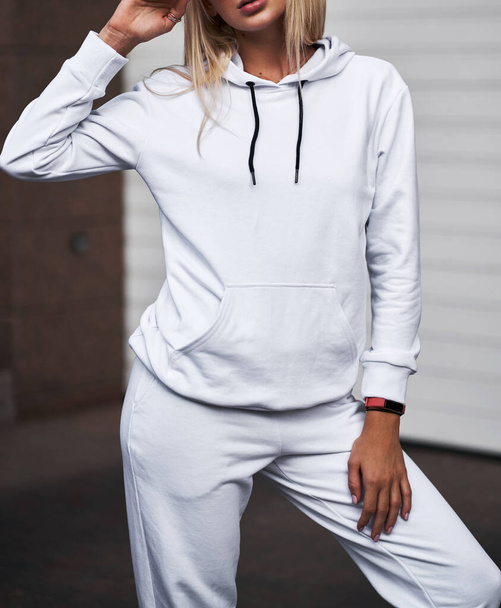for Girl wears white hoodie and pants. Blonde woman in loose tracksuit with no logo - Фото, изображение