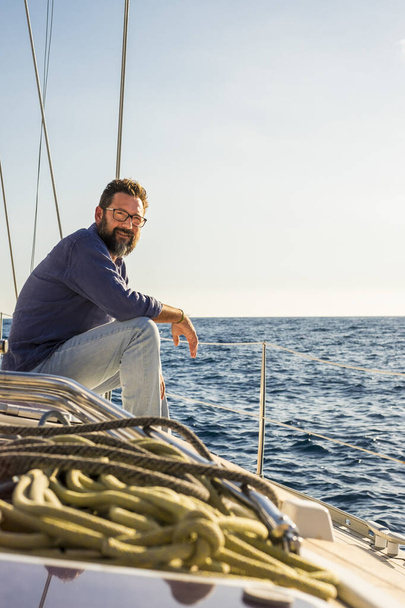 Boldog érett jóképű férfi ül és pihentető vitorlás fedélzeten élvezi a kék óceán utazás kaland egyedül - ingyenes életmód és vidám emberek a jacht vitorlázás - Fotó, kép