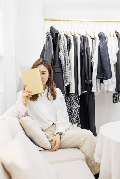 Startup small business, Young chinese woman Entrepreneur using weekly planner in store - Fotó, kép