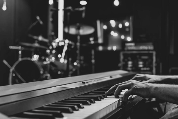 Close-up van de hand pianist op muzikale toetsen op wazig achtergrond. - Foto, afbeelding