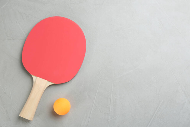 Ping pong racket and ball on grey table, flat lay. Space for text - Valokuva, kuva