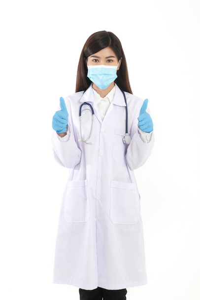 A beautiful Asian woman doctor wearing a blue mask and gloves to prevent infection. And coronavirus (COVID-19). Hospital medical service concept. White background - Foto, Bild